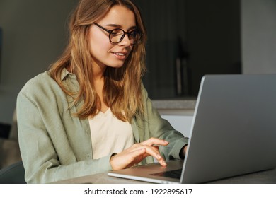 Pleased Beautiful Woman Working With Laptop While Sitting At Home