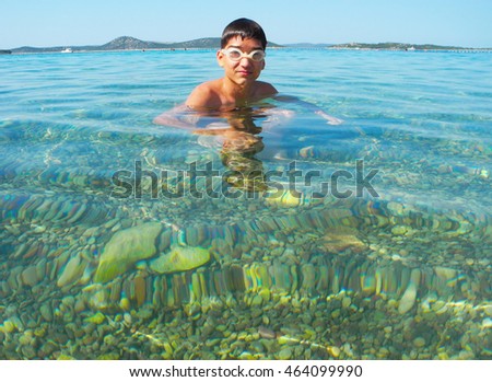 The pleased boy swim from the sea.