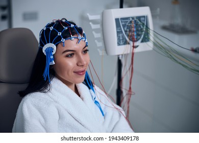 Pleased female patient undergoing an EEG test