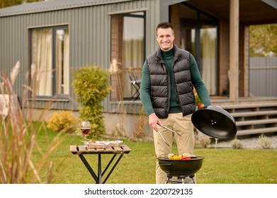 Pleased Guy Grilling Food On The Grill