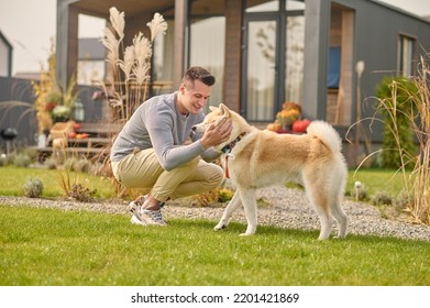 Pleased Man And His Adorable Dog In The Backyard