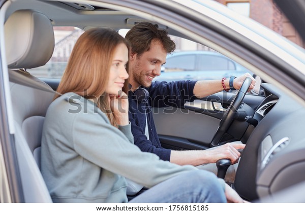 Pleased man and woman resting in car while thinking\
about next destination\
point