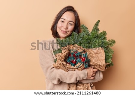 Similar – green spruce branches with brown cones