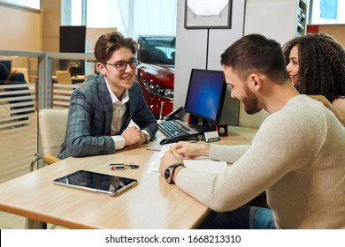 Pleasent Cheerful Couple Buying A New Car At New Car Showroom, Close Up Photo. Bargain, Sale, Discount. Dreams Come True