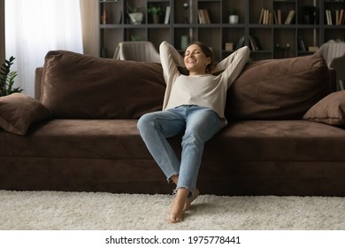 Pleasure Of Being Alone. Peaceful Teenage Female Recline On Cozy Sofa In Modern Flat Relax With Closed Eyes Enjoy Tranquility. Happy Young Lady Rest On Couch At Tidy Living Room After Cleaning Is Done