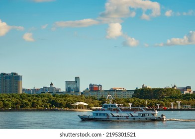 A Pleasure Boat Moves Down The River With The Embankment Of Heihe, China In The Background. Beautiful Blue Sky With Clouds. State Border Between Russia And China. Summer Evening.