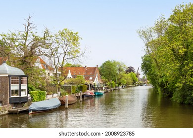 Pleasure boats in the river Vecht with a scaffolding mill in the background in the village of Loenen aan de Vecht.