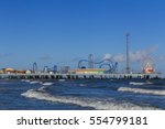 Pleasure Pier from the water/ Galveston Island Pleasure Pier/ The Pleasure Pier rides reaching out over the water on Galveston, Texas, USA.