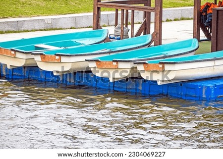 Pleasure rowing boats lie on the pier on a spring day