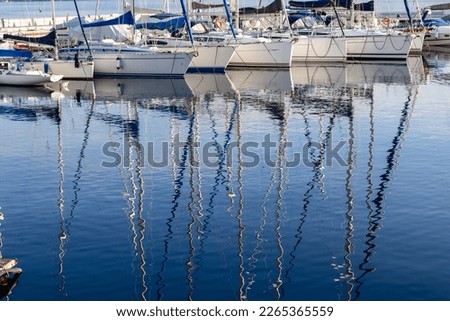 Pleasure yacht masts in the water reflection on Lake Garda in Italy