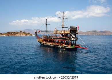 Pleasure Yacht In The Sea. Tourist Ship With People On Board With Turkish Flag Sails On The Waves. Fast Moving Excursion Ship Boat. Marmaris, Turkey - September 9, 202