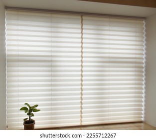 Pleated blinds XL, beige color, with 50mm fold closeup in the window opening in the interior. Home blinds - modern bottom up privacy shades on apartment windows. 