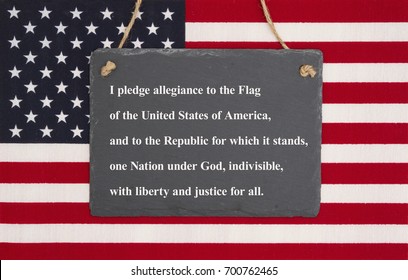 The pledge of allegiance written on a weathered chalkboard over the United States of America flag