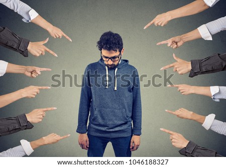 Plenty of crop hands fingers pointing at young man feeling guilty and being introvert. 