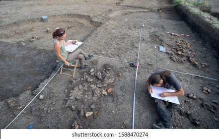 Pleven, Bulgaria - July 05 2019: Two archaeologists prepare documentation side by side during excavation