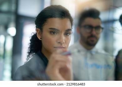 Plotting a course for success. Shot of a group of colleagues brainstorming together on a glass wall in an office. - Powered by Shutterstock