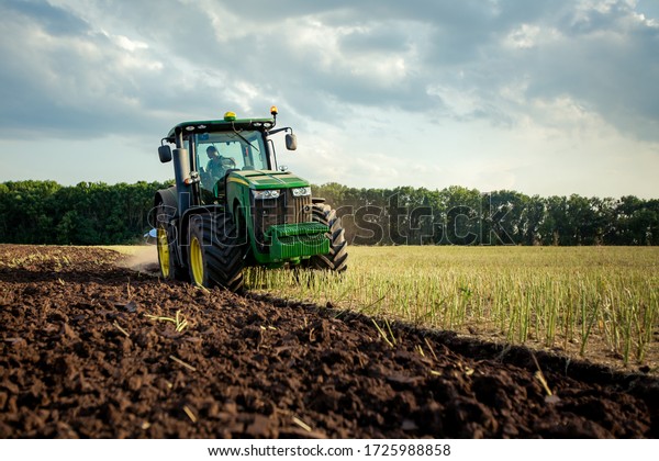 Ploughing a field with John Deere tractor. John\
Deere 8100 was manufactured in 1995-1999. Chernivtsi Oblast,\
Ukraine - July 22th,\
2017