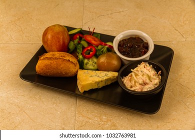 Ploughman's Lunch With Stilton Cheese, Pickle, Pickled Onion, Salad, Coleslaw And Bread Roll And Apple.