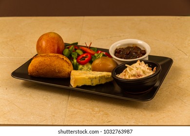 Ploughman's Lunch With Stilton Cheese, Pickle, Pickled Onion, Salad, Coleslaw And Bread Roll And Apple.