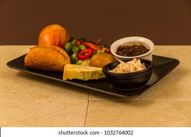 Ploughman's Lunch With Stilton Cheese, Pickle, Pickled Onion, Salad, Coleslaw And Bread Roll And Apple.