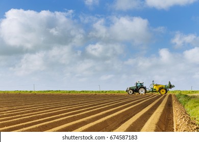 Plowed Agricultural Fields Prepared For Planting Crops In Normandy, France. Countryside Landscape With Cloudy Sky, Farmlands In Spring. Environment Friendly Farming And Industrial Agriculture Concept