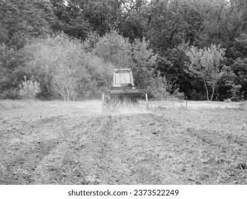 Plowed field by tractor in black soil on open countryside nature, tractor in plowed field, soil to growing tasty vegetables, organic plowed field under the clean dark sky is natural soil for tractor - Powered by Shutterstock