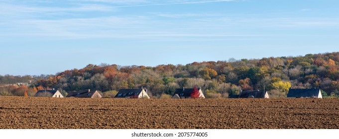 Plowed Field And Houses Near Colorful Autumn Forest In Wallonia Not Far From Namur