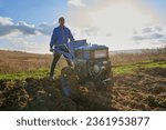 plowing with a tractor at sunset,work in the fall in the field, a man plows with a walk-behind tractor