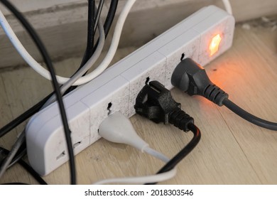 A lot of plug being plugged into old dirty power bar or extension cord. May become fire hazard if overloaded.