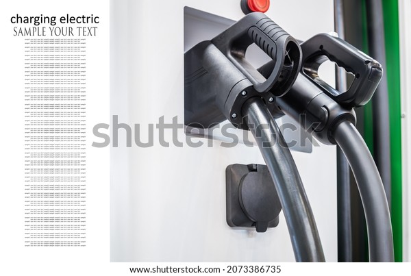 Plug of charging cable\
for charging electric car at an electric charging station in the\
city. Text delete