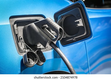 Plug of the charging cable plugged into an electric car. Charging an electric car at the station