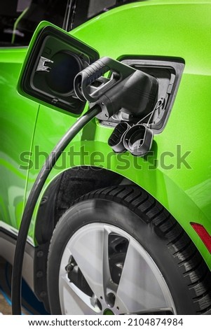 Plug of the charging cable plugged into an electric car. Charging an electric car at the station