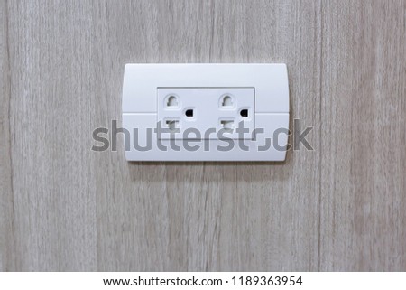 Plug Into Electricity Socket the power outlets on the wood wall. sockets plug outlets with 220 volts (220V) AC style.