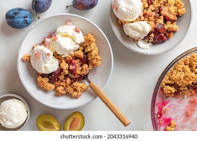 Plum crumble with vanilla ice cream on white background. Summer crispy fruit dessert. Top view. Tasty breakfast - Powered by Shutterstock