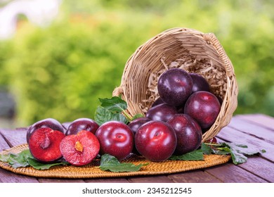 Plum fruit on wooden tray, Red Plums on green bokeh background.