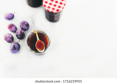 Plum Jam In Glass Jar With Ripe Plums Scattered Around. Making Preserves.