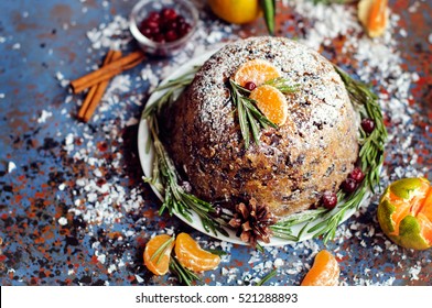 Plum pudding with mandarins and berries on blue vintage background. Copyspace