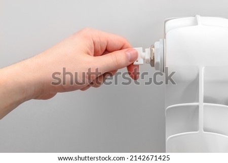 Plumber adjusts ventor air valve on heating radiator. Preparing the house for the new cold winter season. Selective focus