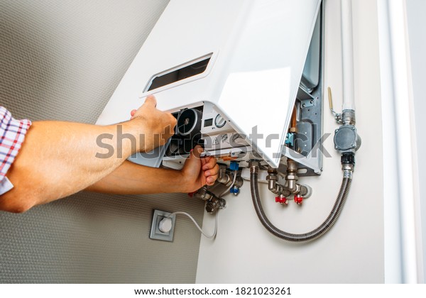 Plumber attaches Trying
To Fix the Problem with the Residential Heating Equipment. Repair
of a gas boiler