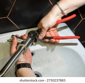 Plumber changes broken, leaking plumbing fixtures in the bathroom. Repair of a water tap. Plumber uses a wrench to install the faucet in the bathroom. An adult man changes the faucet in the kitchen. 