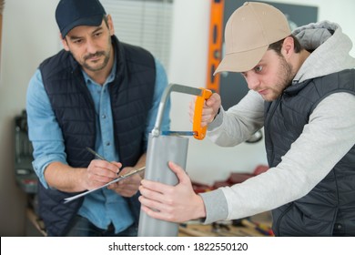 plumber checking apprentice cutting pvc pipe with a saw