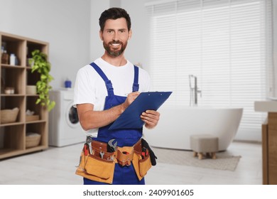 Plumber with clipboard and tool belt in bathroom - Powered by Shutterstock