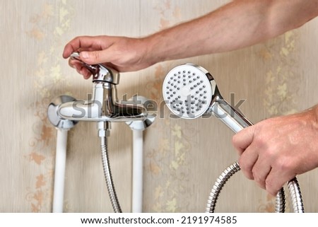 Plumber connected showerhead with flexible hose to single lever faucet in bathroom.