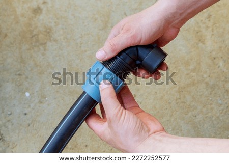 A plumber connects a polyethylene pipe using a special fitting.