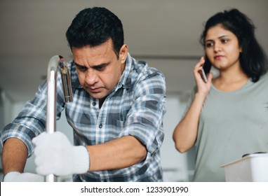 Plumber Fixing The Kitchen Sink