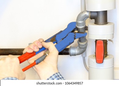 Plumber Is Fixing A Pipe On A Wall