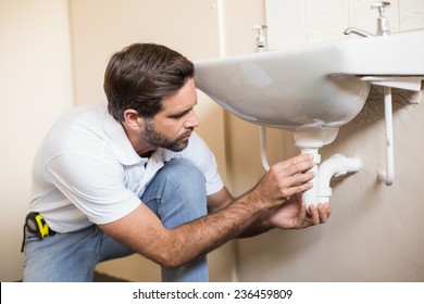 Plumber Fixing The Sink In A Bathroom In A New House