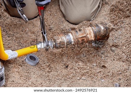 A Plumber hooking up a temporary gas line to a propane tank