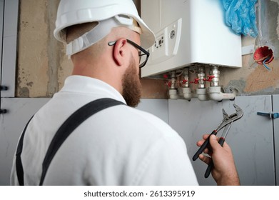 Plomero Instale una caldera. Ingeniero de Profesional instalando caldera de gas en casa y comprobando las conexiones y tuberías del sistema de calefacción doméstica. Sistema de calefacción del servicio de instalación de calderas.
