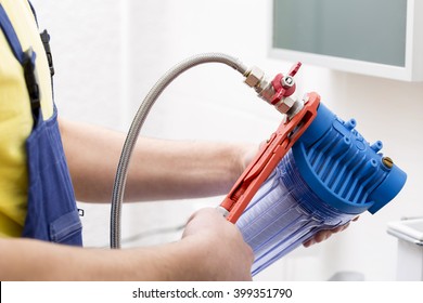 Plumber Installing New Water Filter In Bathroom